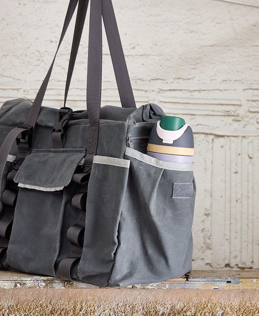 a closeup on a water bottle in the pocket of the garner and tow tote bag