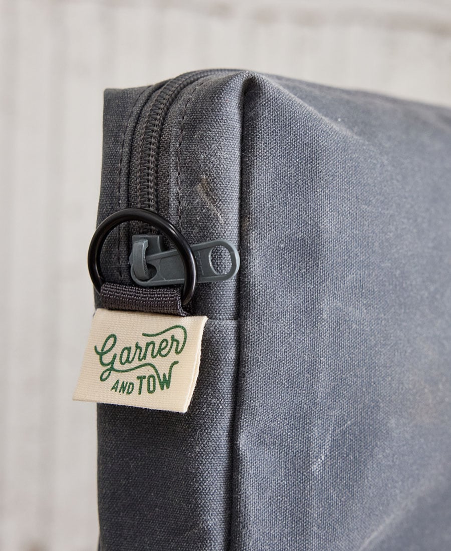 The zipper of a grey fabric pouch
