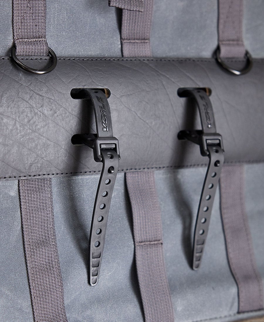 A closeup image of voile straps being used on a grey garner and tow tote bag