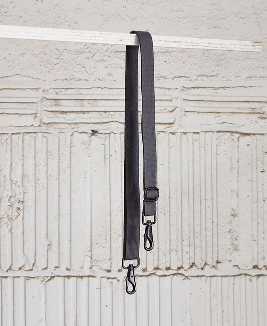 adjustable shoulder strap in gray color, with metal snap hooks, displayed parallel to each other against a wooden background.